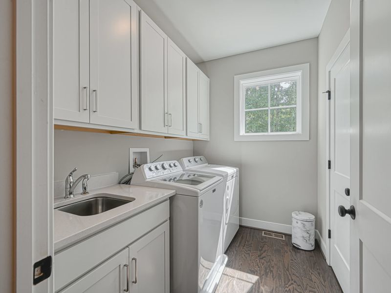 Bright and functional laundry room with a washer, dryer, and ample storage space