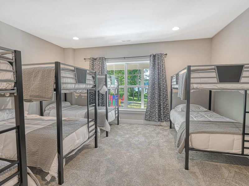 Spacious bunk room with multiple beds, perfect for accommodating large groups or families