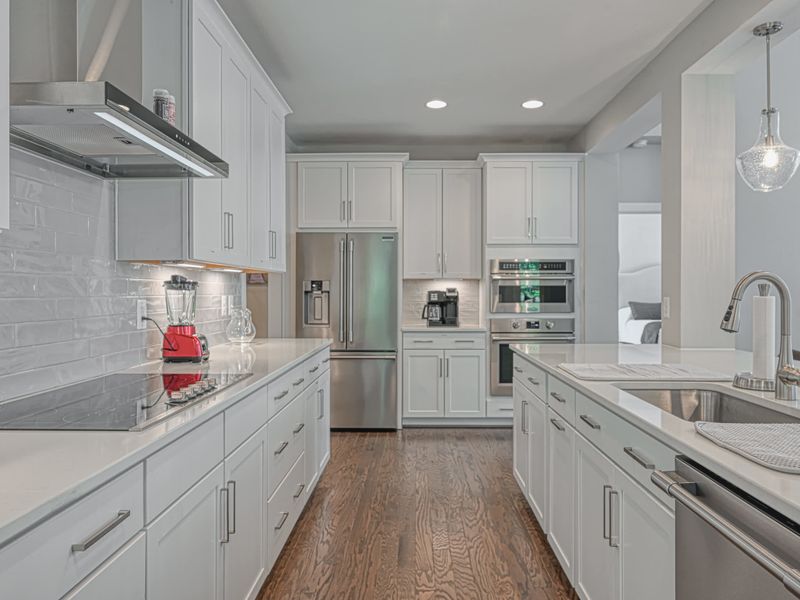 Spacious kitchen with modern appliances, ample counter space, and elegant lighting