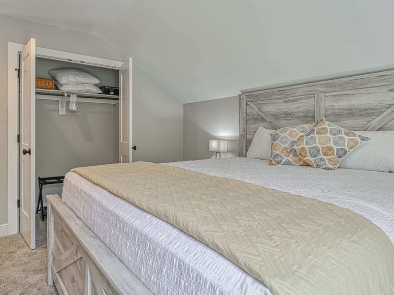 Comfortable bedroom with a king-size bed, open closet, and cozy decor