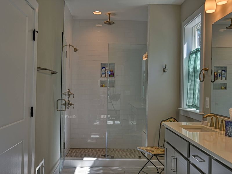 Luxurious bathroom with a double vanity, spacious shower, and elegant lighting