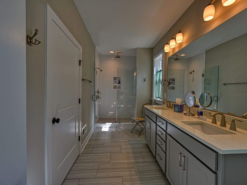 Luxurious bathroom with a double vanity, spacious shower, and elegant lighting