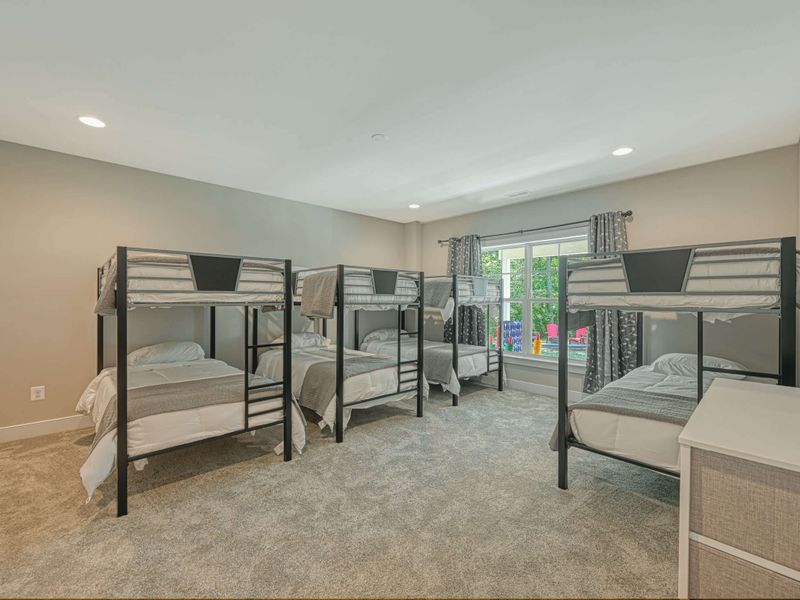 Spacious bunk room with multiple beds, perfect for accommodating large groups or families