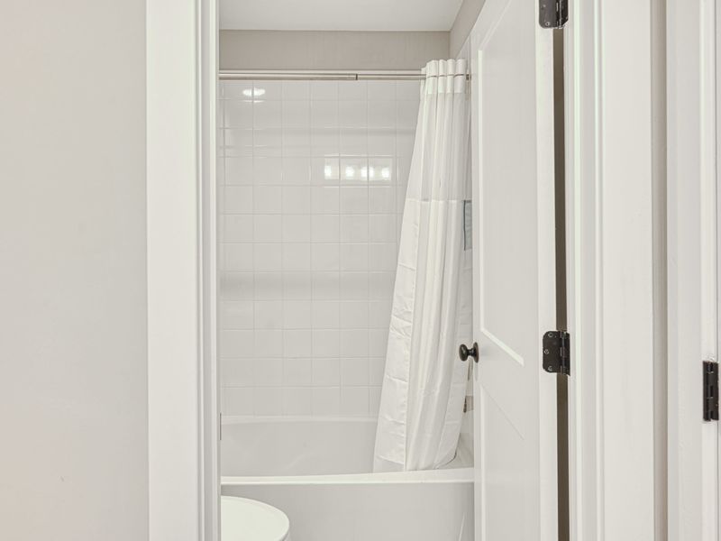Bright and clean bathroom with a bathtub and shower combination
