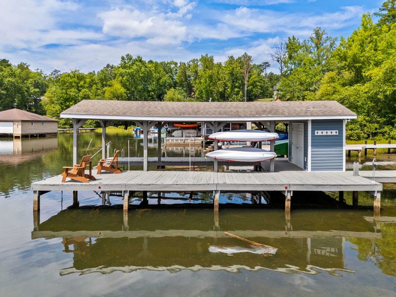 A covered dock featuring a spacious boat slip and scenic lake views, providing the perfect setup for boating enthusiasts and lakeside relaxation.