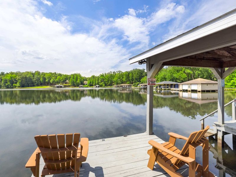 Charming dock with Adirondack chairs overlooking a peaceful lake, perfect for unwinding or enjoying the water views