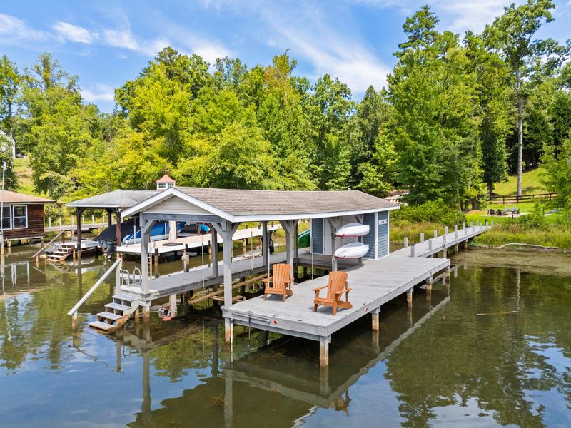 A covered dock featuring a spacious boat slip and scenic lake views, providing the perfect setup for boating enthusiasts and lakeside relaxation.
