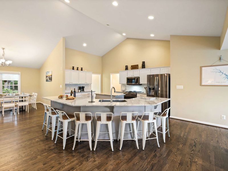 A spacious and modern kitchen with a large marble island, plenty of seating, and an open layout connected to the dining area, perfect for entertaining and family meals.