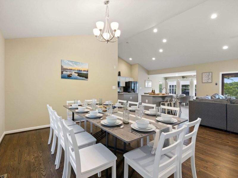 A bright and spacious dining area with a large table set for gatherings, seamlessly flowing into the open-concept living room for a welcoming and social atmosphere.