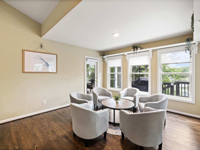 A cozy sitting area with plush chairs and a round table, seamlessly connected to an open kitchen and living space, creating a warm and inviting atmosphere.