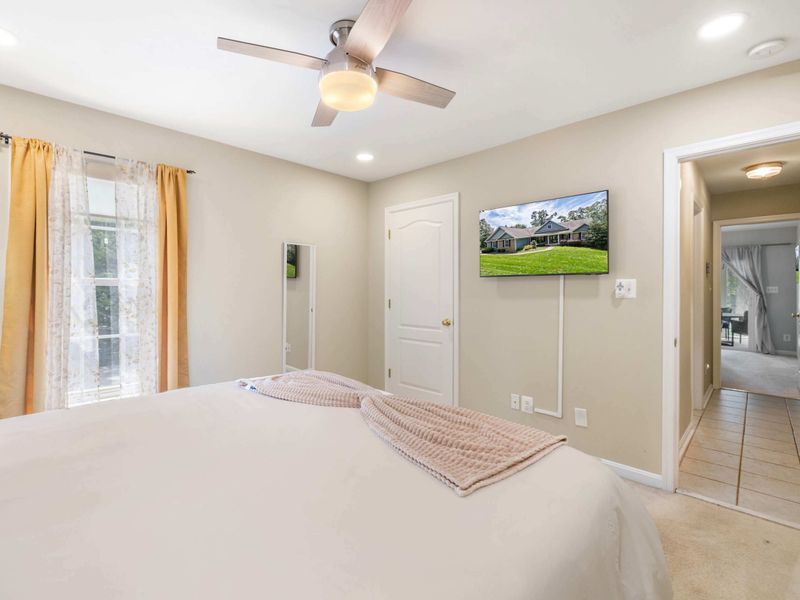 A bright and inviting bedroom featuring a king-size bed, warm tones, and modern furnishings, perfect for a comfortable and restful stay.