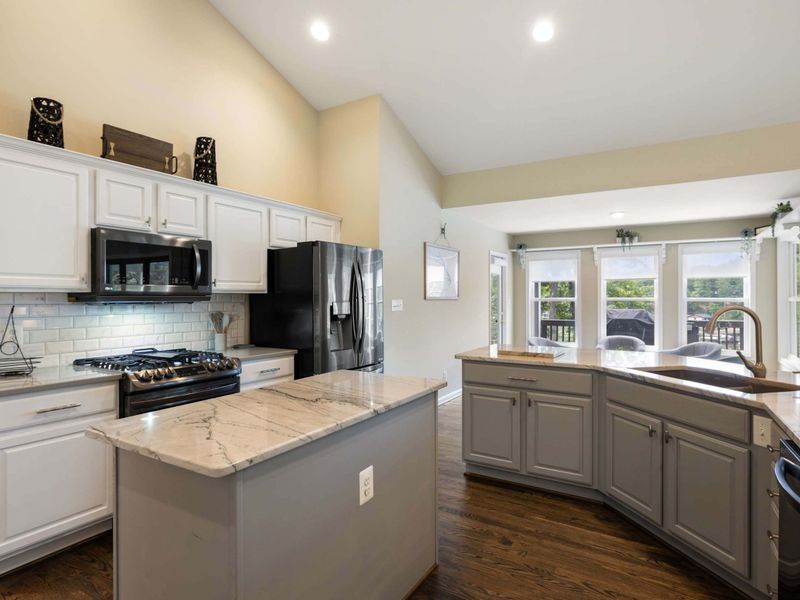 A spacious and modern kitchen with a large marble island, plenty of seating, and an open layout connected to the dining area, perfect for entertaining and family meals.