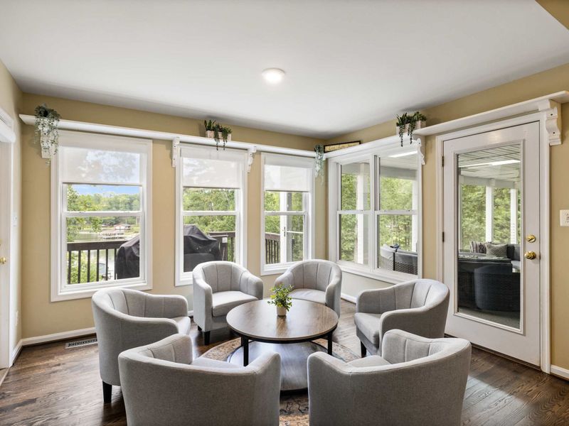 A cozy sitting area with plush chairs and a round table, seamlessly connected to an open kitchen and living space, creating a warm and inviting atmosphere.