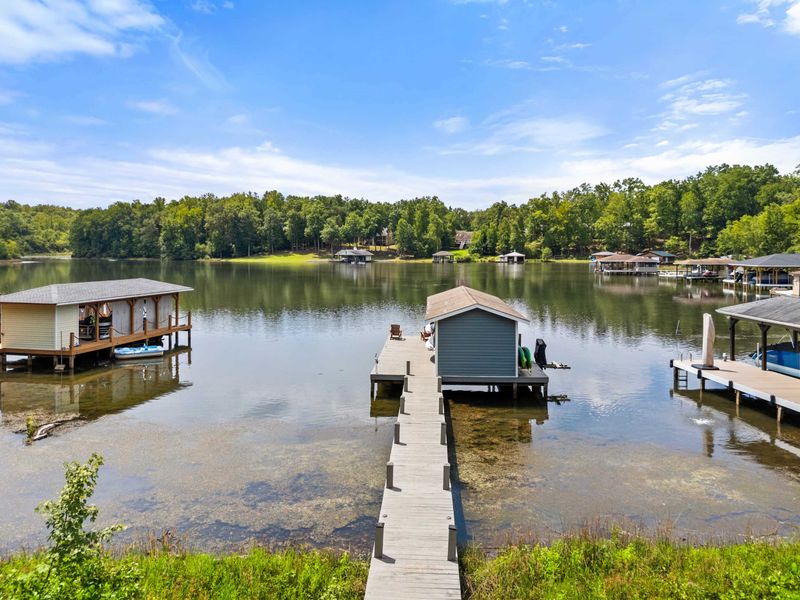 A covered dock featuring a spacious boat slip and scenic lake views, providing the perfect setup for boating enthusiasts and lakeside relaxation.
