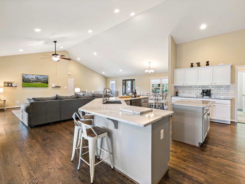 A spacious and modern kitchen with a large marble island, plenty of seating, and an open layout connected to the dining area, perfect for entertaining and family meals.