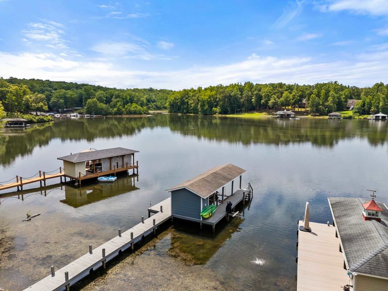 A covered dock featuring a spacious boat slip and scenic lake views, providing the perfect setup for boating enthusiasts and lakeside relaxation.