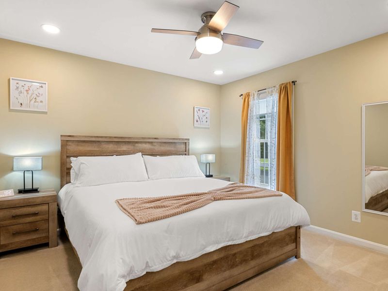 A bright and inviting bedroom featuring a king-size bed, warm tones, and modern furnishings, perfect for a comfortable and restful stay.