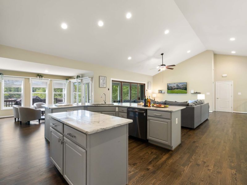 A spacious and modern kitchen with a large marble island, plenty of seating, and an open layout connected to the dining area, perfect for entertaining and family meals.
