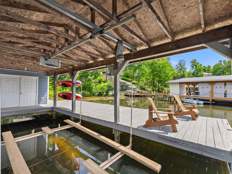 A covered dock featuring a spacious boat slip and scenic lake views, providing the perfect setup for boating enthusiasts and lakeside relaxation. (boat lift not for guest use)