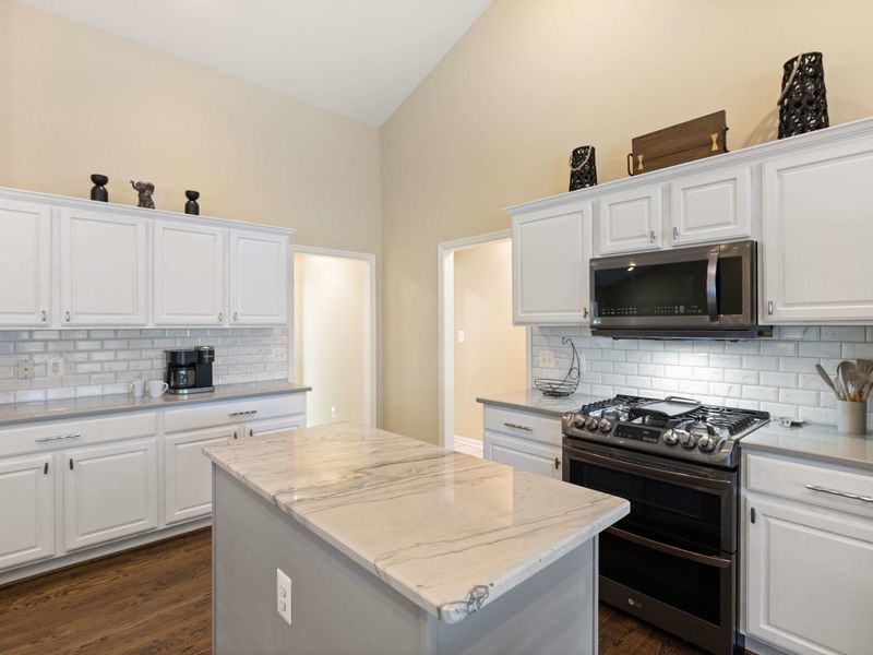 A spacious and modern kitchen with a large marble island, plenty of seating, and an open layout connected to the dining area, perfect for entertaining and family meals.
