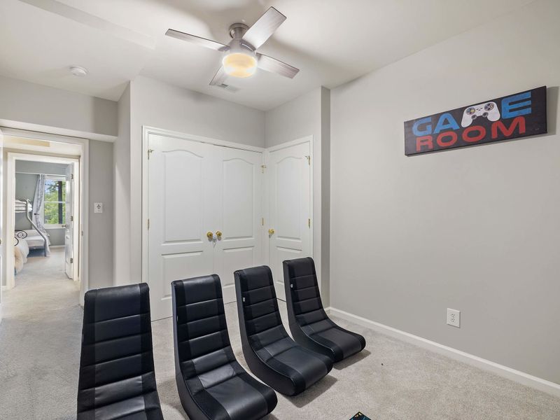 A cozy gaming room with comfortable seating, a TV, and playful decor, creating the perfect space for video games or movie time.