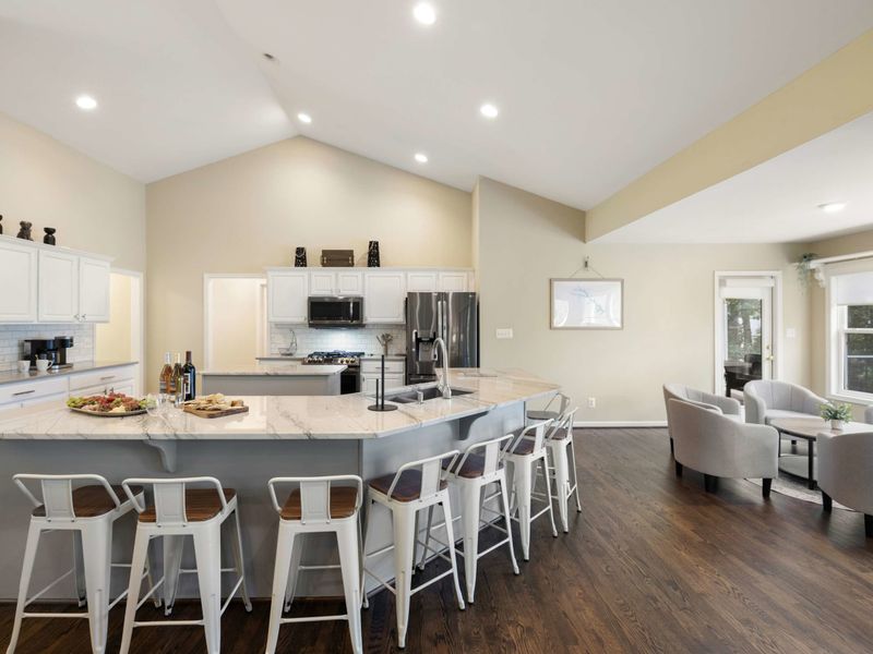 A spacious and modern kitchen with a large marble island, plenty of seating, and an open layout connected to the dining area, perfect for entertaining and family meals.