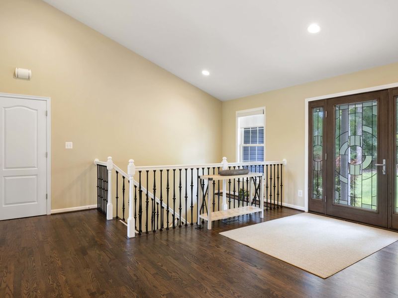 A welcoming entryway with elegant double doors, hardwood flooring, and a bright, open layout leading to the rest of the home.