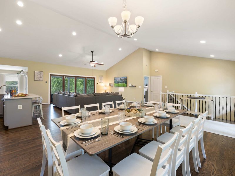 A bright and spacious dining area with a large table set for gatherings, seamlessly flowing into the open-concept living room for a welcoming and social atmosphere.