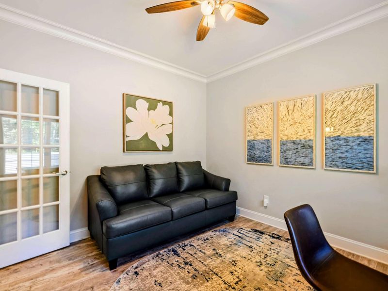 Office - Alternate angle showing the leather sofa, magnolia canvas, ocean triptych, and French glass door entry.