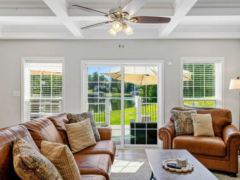 Bright and inviting living room with cozy seating and large windows offering scenic views of the lake