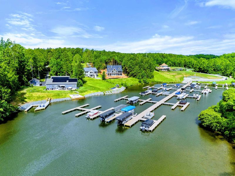 Aerial - Drone view of the marina and community dock area with multiple boat slips and waterfront homes.