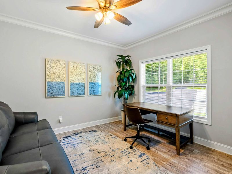 Office - Dedicated workspace with a wooden desk, leather chair, ocean triptych art, and a leather sleeper sofa.