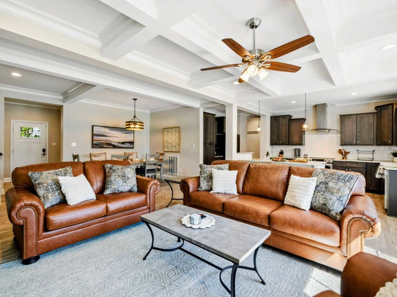 Open-concept living area with comfortable seating, stylish decor, and seamless flow into the dining and kitchen spaces