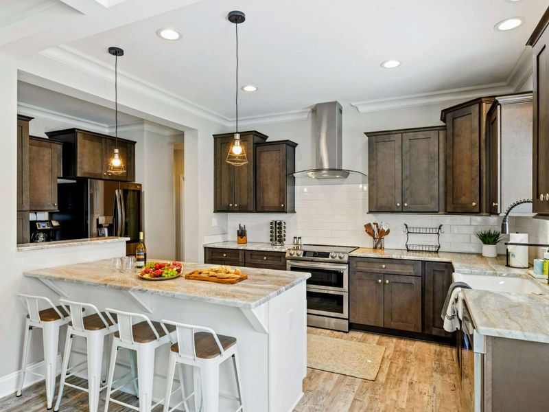 Modern kitchen with a large island, stylish pendant lighting, and bar seating, perfect for cooking and casual dining