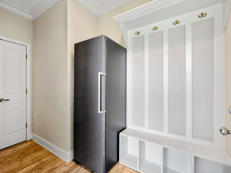 Mudroom - Built-in cubbies with hooks for coats and bags, plus a stainless steel beverage fridge for grab-and-go drinks.
