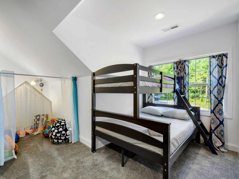 Charming kids' room with bunk beds and a cozy play nook, offering a fun and comfortable space for children