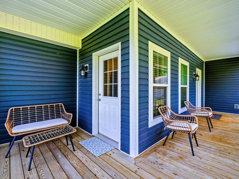 Front Porch - Wraparound covered porch with a rattan loveseat and chairs, perfect for relaxing with morning coffee.