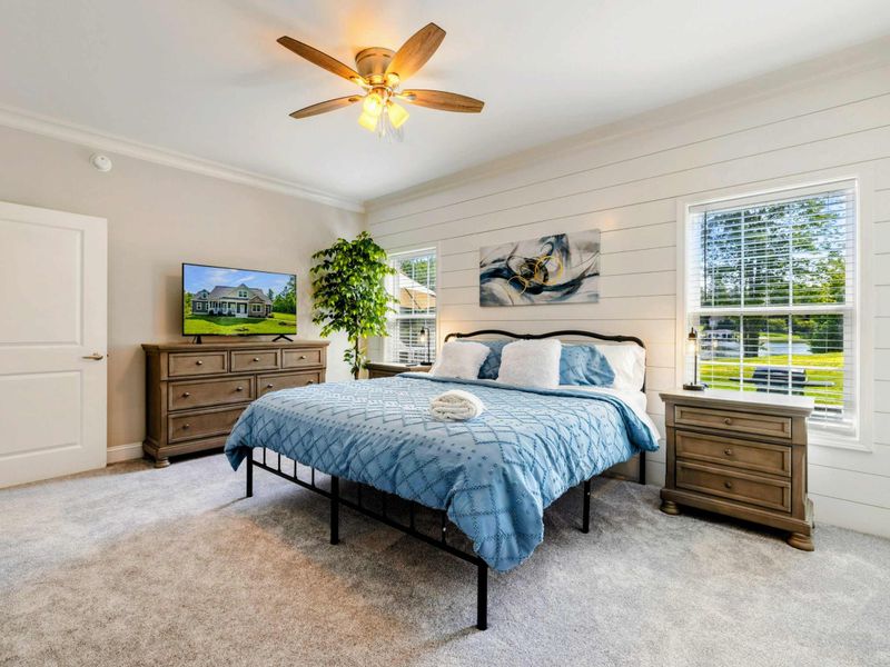 Primary Suite - Spacious and bright bedroom with a king-sized bed, modern decor, and plenty of natural light