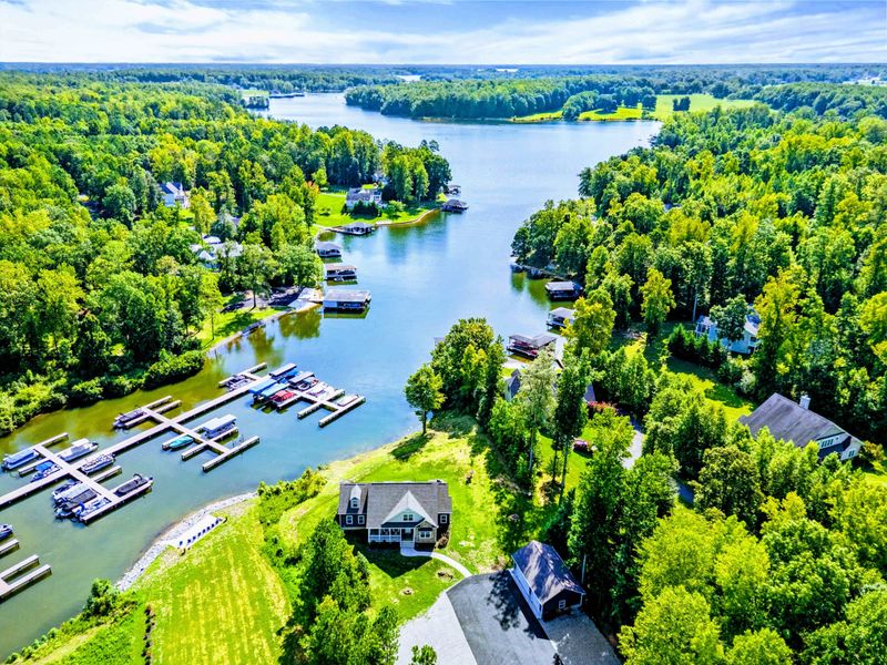 Stunning aerial view of a lakefront property nestled in a peaceful, wooded cove with nearby marina access