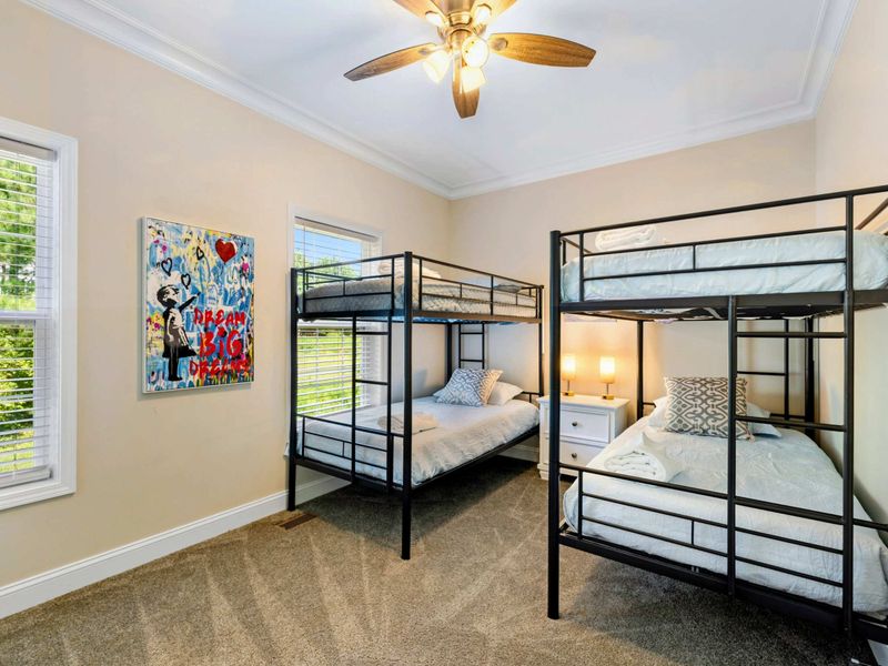 Bunk Room - Two full-over-full metal bunk beds with a colorful street art canvas and tropical ceiling fan.