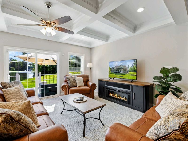 Cozy living room with a fireplace, plush seating, and direct access to a sunny outdoor deck