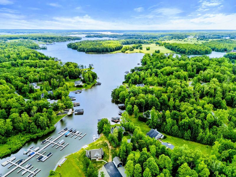 Aerial - High-altitude drone view of the Lake Anna cove, marina, and the forested shoreline stretching to the horizon.