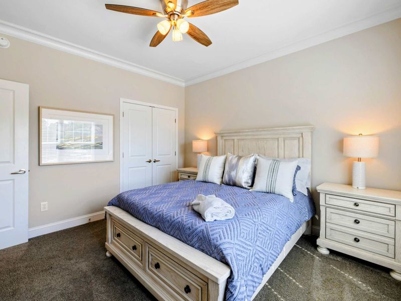 Bedroom - Queen bed with whitewashed furniture, double closet doors, and a cozy layout with warm overhead lighting.