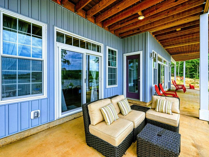 Covered patio area with cozy seating, offering a comfortable outdoor space to enjoy lake views in any weather