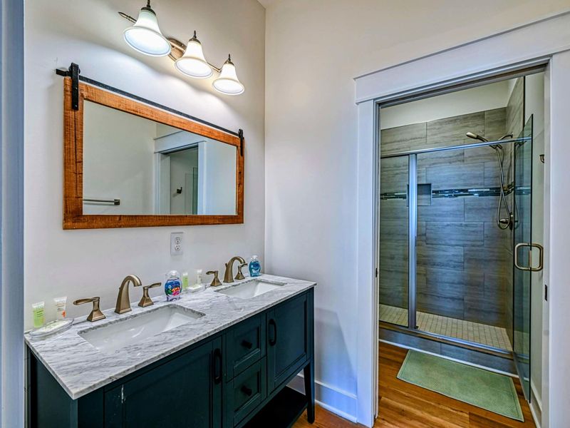 Modern bathroom with a double vanity, large walk-in shower, and stylish lighting, offering a comfortable and functional space