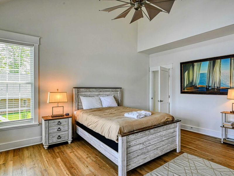 Cozy bedroom with a rustic wood bed frame, modern decor, and plenty of natural light, creating a warm and inviting atmosphere