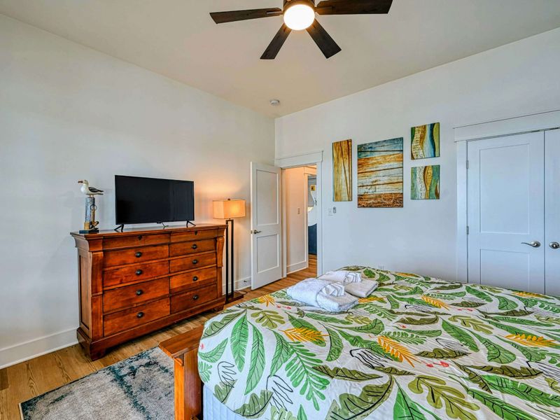 Comfortable bedroom with a tropical vibe, equipped with a TV and ample storage for a relaxing stay