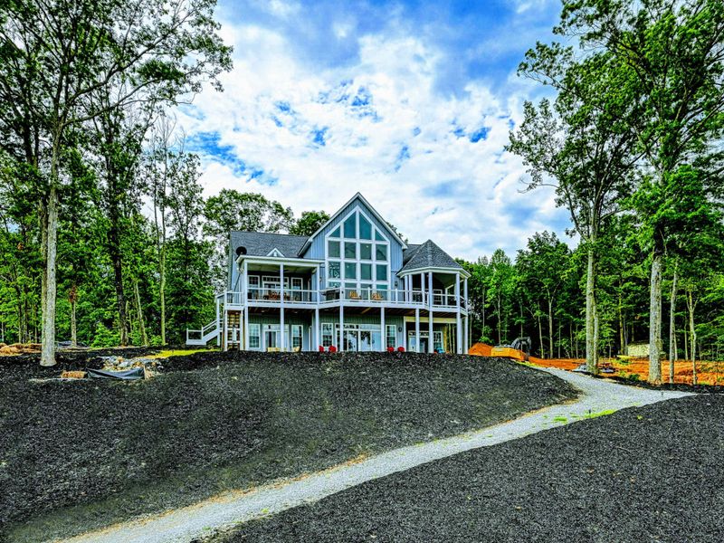 Elegant and spacious lakefront home with large windows, surrounded by nature, offering a peaceful retreat
