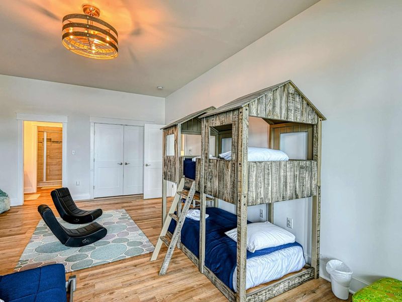 Charming kids' room featuring rustic bunk beds, cozy chairs, and ample space for play and relaxation