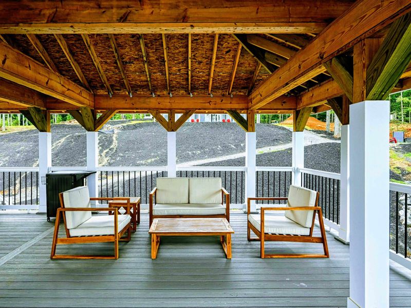 Charming covered outdoor seating area with comfortable furniture, ideal for relaxing in a shaded, open-air space